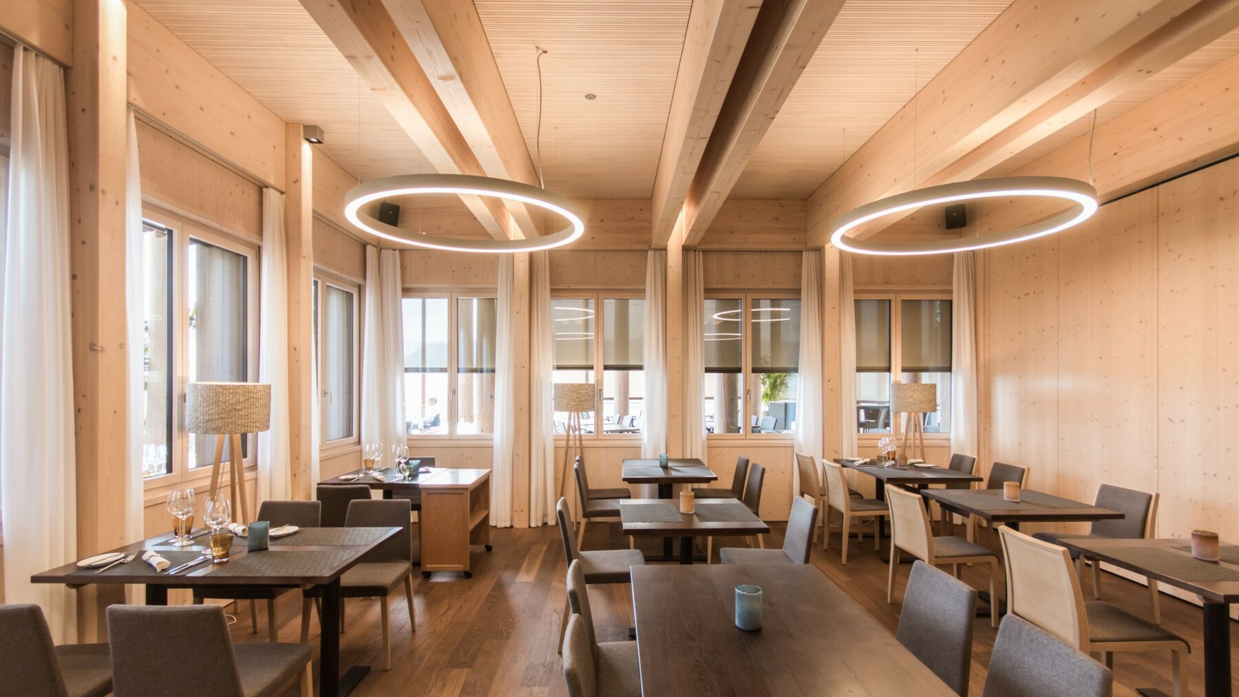 Im Speisesaal des Restaurants Golfpark Holzhäusern herrscht dank an der Decke angebrachten Akustik Light made of LIGNO® auch bei viel Umtrieb eine gute Raumatmosphäre. 