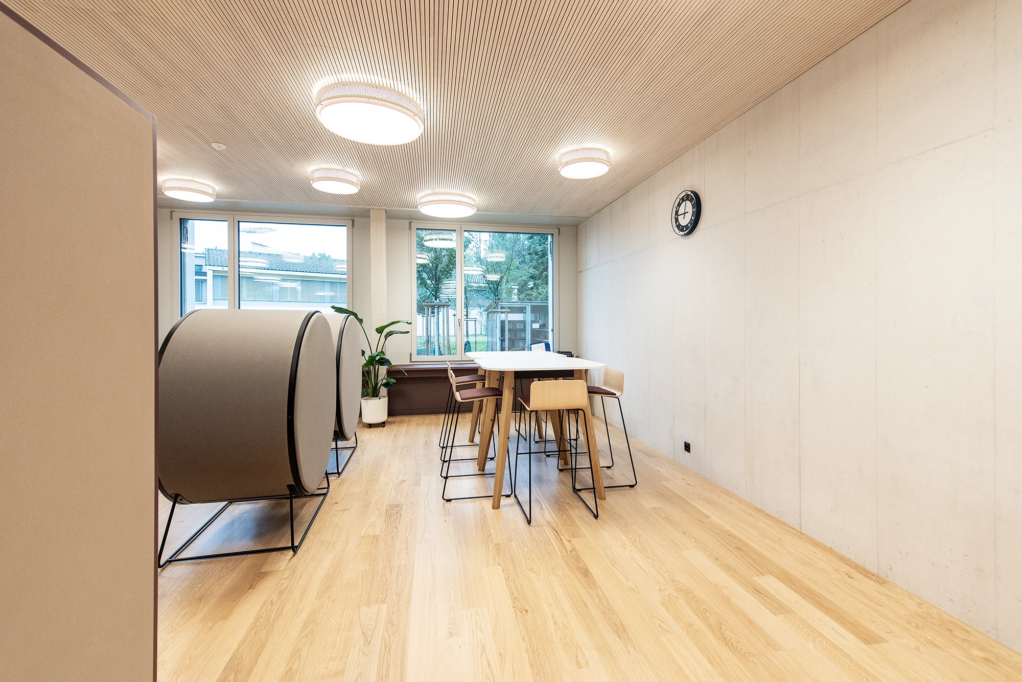 Multifuntionaler Raum mit schallabsorbierender Deckenverkleidung aus natürlichem Holz