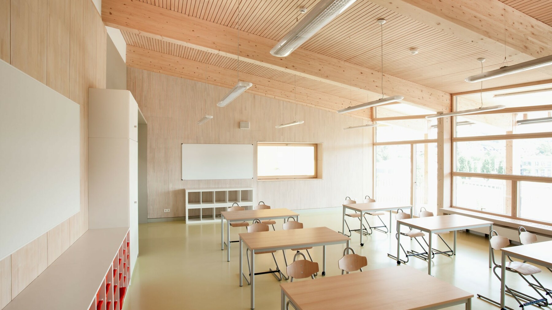 Die verbauten LIGNO® Elemente sind im Klassenzimmer als edle Holzoberflächen in Weißtanne sichtbar, an der Decke mit integriertem Akustikprofil für eine optimale Raumakustik.