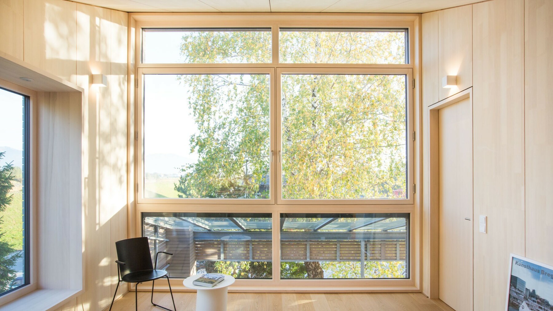 Die bodentiefe Fensterfront lässt hier viel Sonnenschein ins Innere und betont nochmals die Verbundenheit des Klimaholzhauses mit der Natur. 