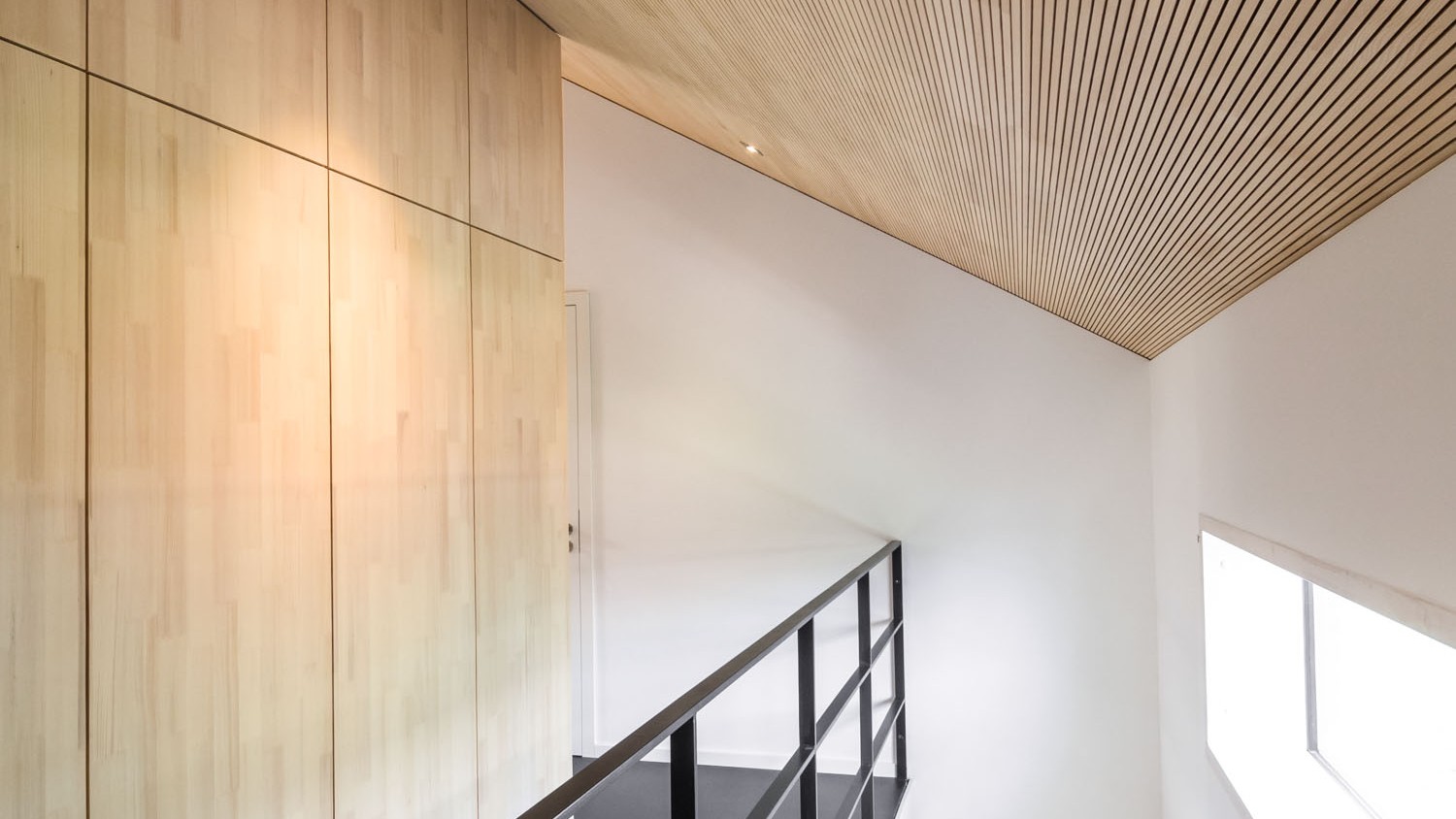 Die klaren Linien der Galerie verleihen dem Raum, trotz minimalistischer Einrichtung ein bewegtes Raumbild, das durch die feine Profilierung der abgeschrägten Decke verstärkt wird. 