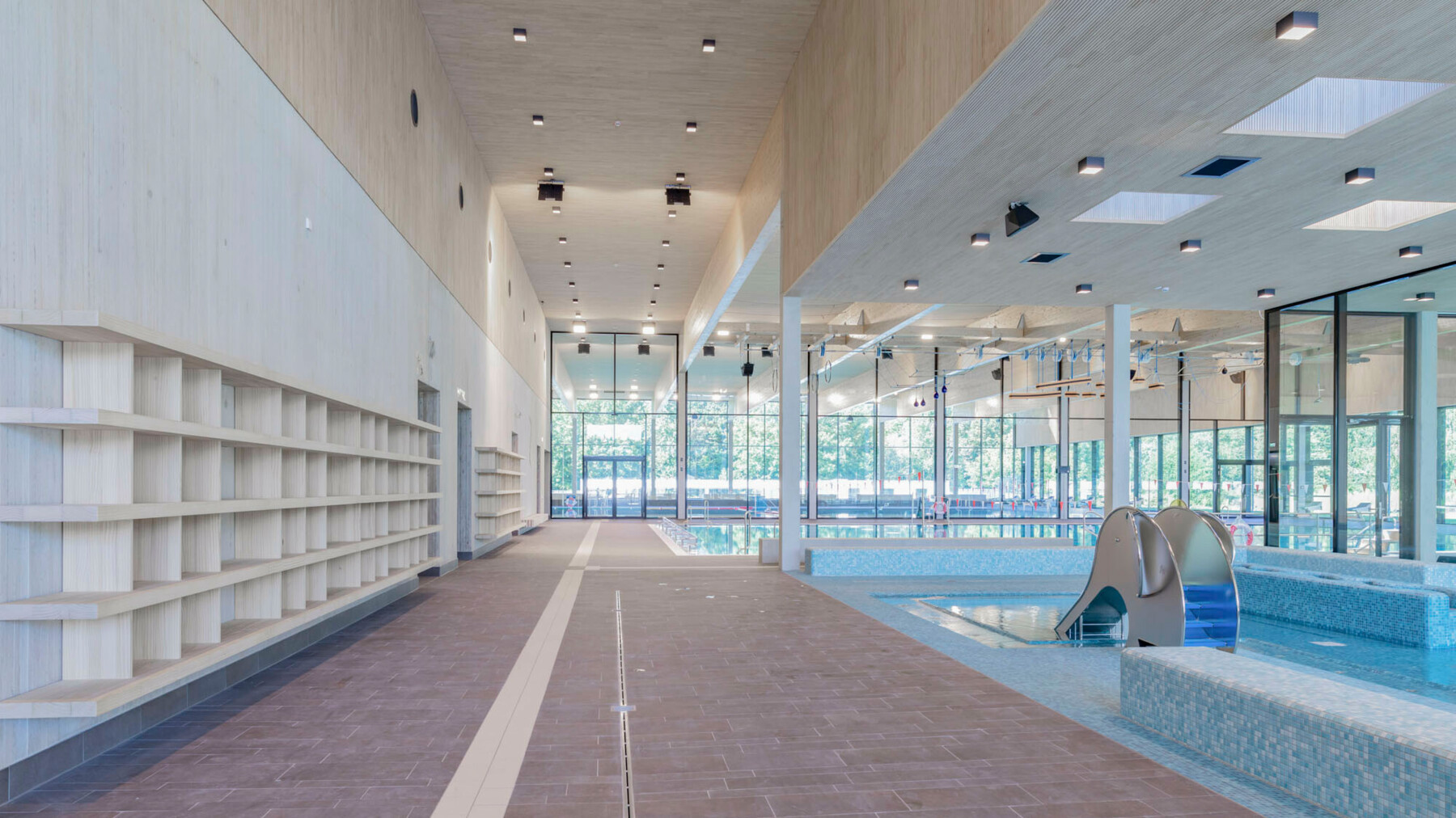 Mit dem Naturmaterial Holz an Decken und Wänden entsteht in diesem Schwimmbad eine angenehme, warme Raumatmosphäre. 