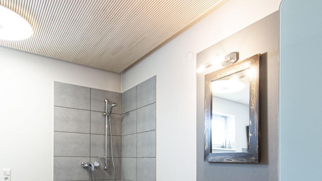 Die wohngesunde Akustikverkleidung mit Echtholz-Oberflächen sorgt auch im Badezimmer für eine angenehme Atmosphäre.