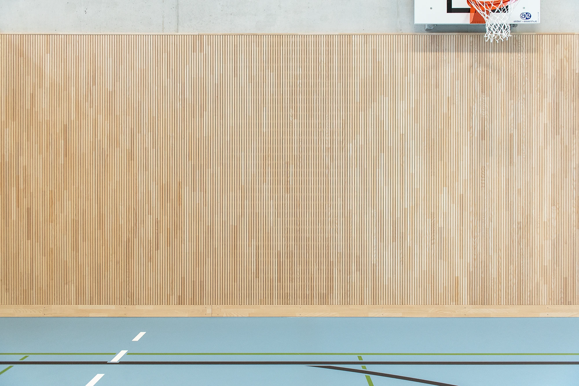 Die robuste Esche-Oberfläche der LIGNO® Akustik Sport Prallwand ist splitterfrei und stoßfest – ideal für Sporthallen.